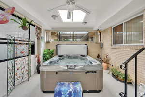 View of patio / terrace with a hot tub, a sunroom, and ceiling fan
