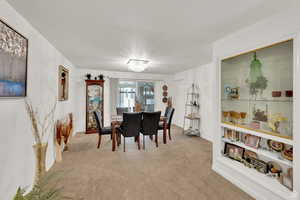 Dining area featuring light carpet and a chandelier