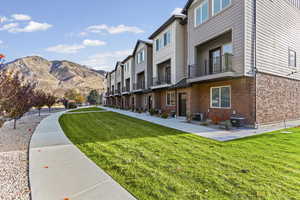 Surrounding community featuring a balcony, a residential view, a yard, and a mountain view