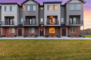 View of front of property with a standing seam roof, brick siding, and a metal roof