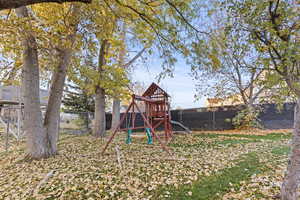 Fenced backyard featuring a playground