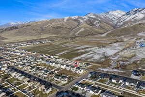 Aerial view of property and surrounding area with mountains and nearby suburban area