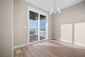 Unfurnished dining area featuring a mountain view, light wood-style floors, and a chandelier