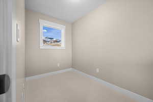 Carpeted spare room featuring baseboards