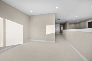 Unfurnished room with recessed lighting and light carpet
