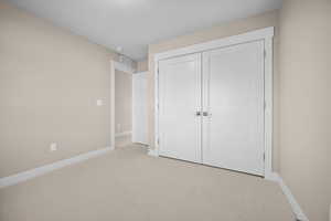 Unfurnished bedroom with carpet and a closet