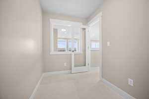 Spare room featuring baseboards and carpet floors