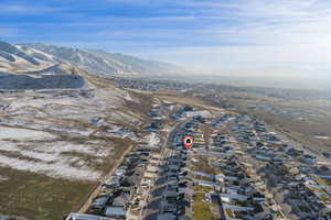 Aerial view of property's location with nearby suburban area and a mountainous background