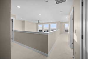 Hall with light carpet, recessed lighting, and an upstairs landing