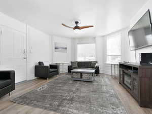 Living room with a ceiling fan and light wood-type flooring