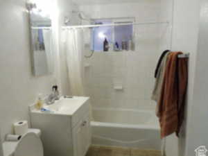 Bathroom with shower / tub combo, vanity, and tile patterned flooring
