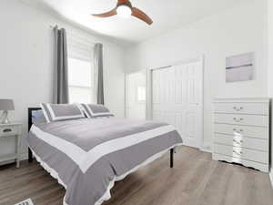 Bedroom featuring light wood-style floors, ceiling fan, and a closet