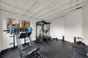 Workout area with wooden walls and beamed ceiling