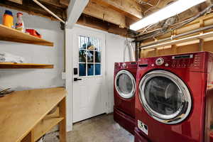 Laundry area with washer and dryer and unfinished concrete floors