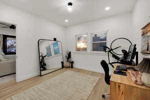 Office space with light wood-style flooring and recessed lighting