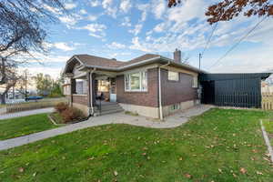 View of side of property featuring a chimney and brick siding
