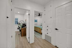 Corridor featuring a desk and light wood-style floors