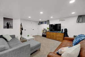 Living area with light colored carpet and recessed lighting