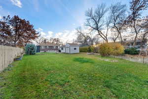 Fenced backyard with an outbuilding