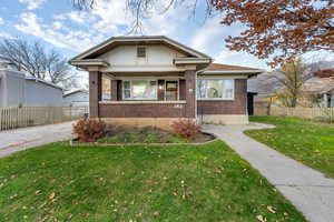 Bungalow-style house with brick siding and a porch