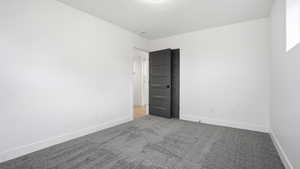 Carpeted empty room featuring baseboards