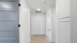 Hall featuring light wood-type flooring and baseboards