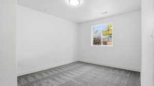 Carpeted empty room with baseboards and a textured ceiling