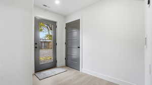 Entrance foyer with baseboards and light wood finished floors