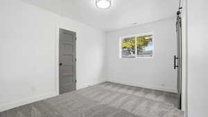 Spare room with light colored carpet and baseboards