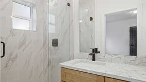 Full bathroom with a marble finish shower and vanity