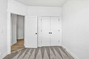 Unfurnished bedroom with light colored carpet and a closet
