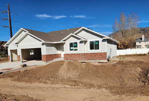 View of front facade with board and batten siding, brick siding, concrete driveway, and an attached garage