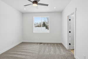 Empty room featuring light carpet, a ceiling fan, and recessed lighting