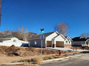 View of front of home with a garage, driveway, board and batten siding, brick siding, and a mountain view