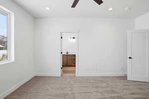 Unfurnished bedroom featuring light carpet, ensuite bath, ceiling fan, and recessed lighting