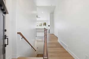 Stairs with wood finished floors and recessed lighting