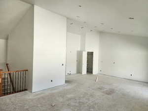 Unfurnished room featuring high vaulted ceiling