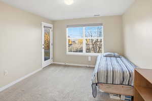 Unfurnished bedroom with light carpet and access to exterior