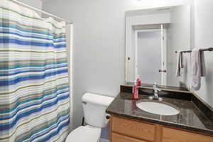 Bathroom with a shower with curtain and vanity