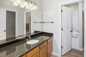 Full bath with vanity, a bath, a shower with curtain, a walk in closet, and light wood-type flooring
