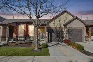Single story home with concrete driveway, covered porch, a front lawn, a shingled roof, and stucco siding