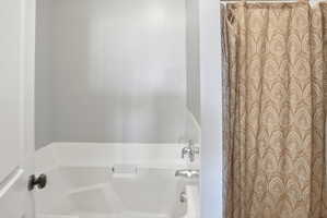 Bathroom with a bathtub and curtained shower