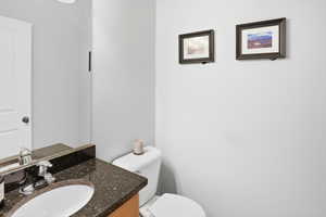 Half bathroom featuring vanity and toilet