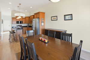 Dining space with light wood-style floors and recessed lighting