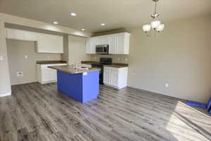 Kitchen featuring black electric range, recessed lighting, white cabinets, pendant lighting, and dark wood-style floors