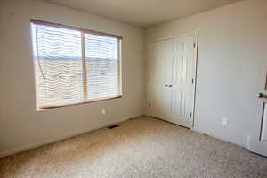 Unfurnished bedroom featuring carpet and a closet