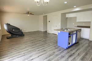 Kitchen featuring white cabinets, open floor plan, dark wood-type flooring, dark countertops, and recessed lighting