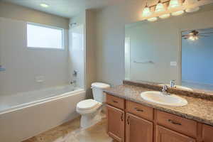 Owner's Suite Bathroom with vanity,  shower combination, light tile patterned flooring, and a ceiling fan