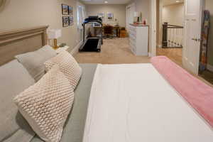 Bedroom with an office area, light colored carpet, recessed lighting, and a closet