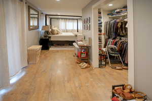 Bedroom featuring light wood finished floors, a closet, and recessed lighting